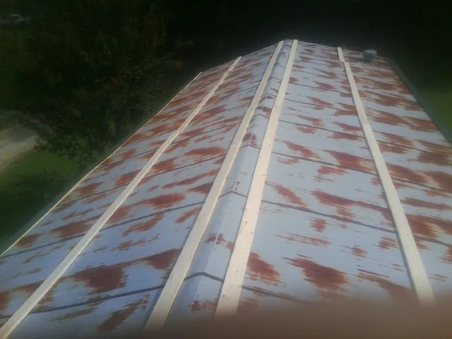 Rusted metal roof panels with new wood purlins before replacement — Storm Damage Roof Repair in Townsend by Roofing Brothers