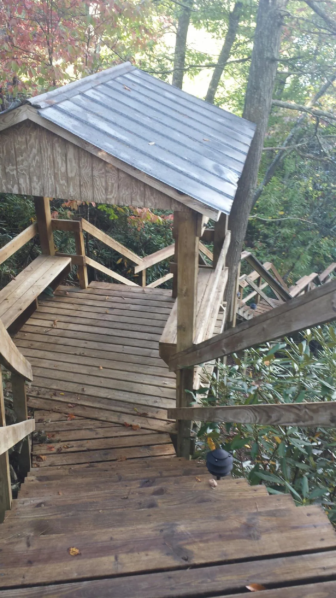 Metal roofed shelter over wooden steps on a wooded walkway — Skylight Repair & Installation work by our crew in Townsend